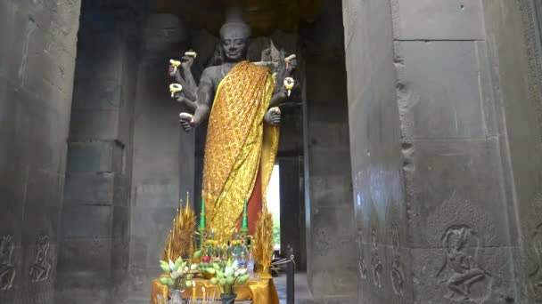 Широкий наклон вверх снимок статуи Вишну у входа в храм Ангкор Ват — стоковое видео
