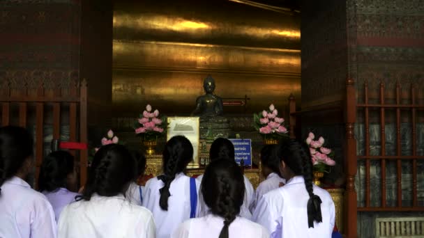 BANGKOK, THAILAND-JUNE, 21, 2017: wide shot of school girls worship at wat pho bangthe — 图库视频影像