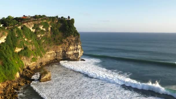 Atardecer de cerca mirando al este de los acantilados y navegar en el templo uluwatu en Bali — Vídeos de Stock