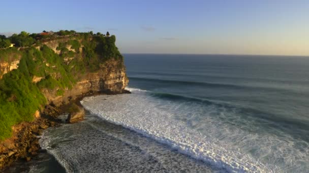 Bali 'de günbatımında kayalıkların ve uluwatu tapınağının geniş bir görüntüsü. — Stok video