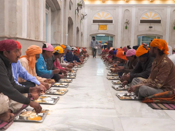 DELHI, INDIA - 2019. március 13.: emberek esznek a gurudwara bangla sahib langar csarnokban Új-Delhiben — Stock Fotó