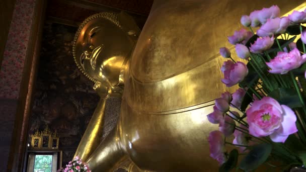 Vista próxima do buddha reclinado e flores no templo wat pho em bangkok — Vídeo de Stock