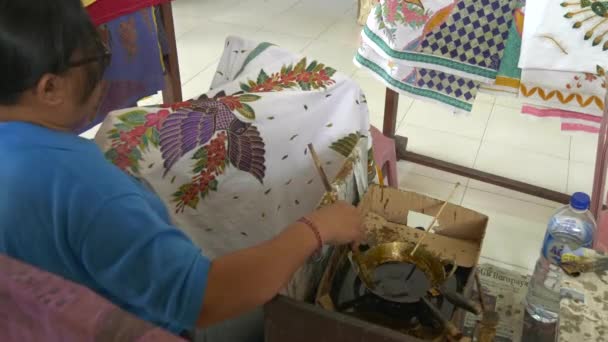 Gianyar, Indonesië - 19 juni 2017: breed zicht op een kunstenaarsschilderij van batikstof op het eiland bali — Stockvideo