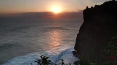 Bali adasında batan bir güneşe ve uluwatu tapınağına bakıyorum.