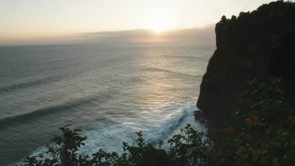 Wijds uitzicht op uluwatu tempel en surf break bij zonsondergang op bali — Stockvideo