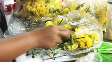 Bangkok 'taki Sri Maha Denizci Tapınağı' nda çiçek hazırlayan bir çiçekçiyi kapatın.