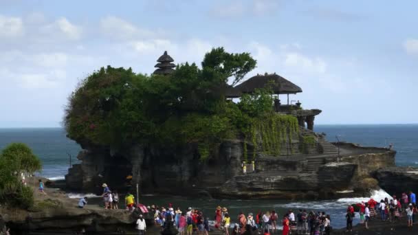 Τουρίστες επισκέπτονται το ναό Tanah παρτίδα κατά τη διάρκεια της υψηλής παλίρροιας — Αρχείο Βίντεο