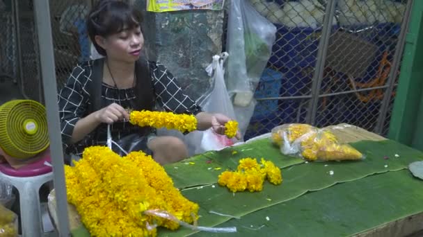 BANGKOK,アンド- 6月, 22, 2017バンコクでマリーゴールドのガーランドを作るタイの女性 — ストック動画