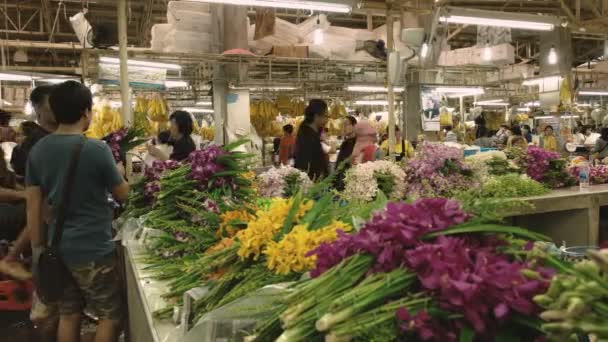 BANGKOK, THAILAND - 22. JUNI 2017: Zwei thailändische Einkäufer inspizieren Orchideen auf dem Pak Khlong Talat Blumenmarkt in Bangkok — Stockvideo