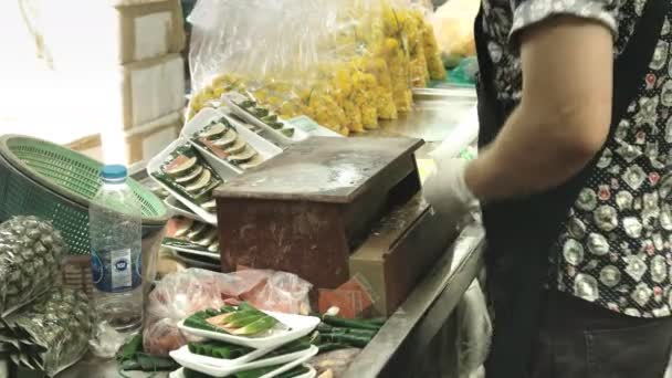 Taylandlı bir kadın, Bangkok 'taki Pak Khlong Talat çiçek pazarındaki tepsilere plastik film uyguluyor. — Stok video