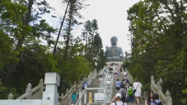 HONG KONG, ÇİN-EYLÜL, 30, 2017: bronz Buda 'ya giden basamakları tırmanan ziyaretçiler — Stok video