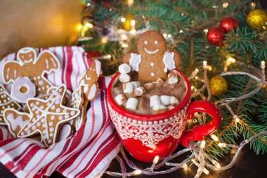 Sıcak çikolata ve şekerleme ve gingerbread çerezleri ile kırmızı kupalar. Noel tatil kavramı