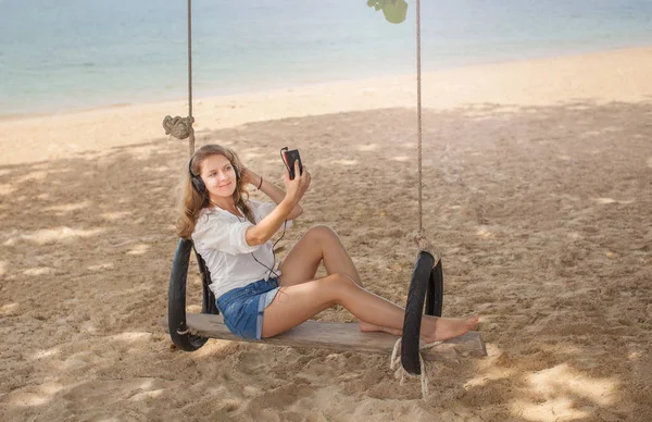 Menina sentada no balanço na praia tropical, ilha paradisíaca Fotos De Bancos De Imagens