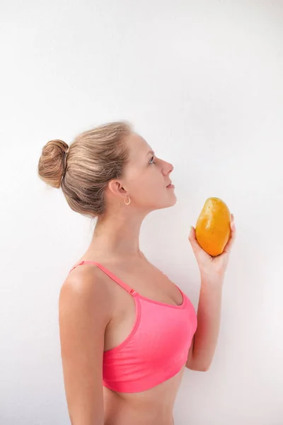 Portrait of a pretty young summer girl holding mango isolated over  background. Concept of a healthy lifestyle. — Stock Photo, Image