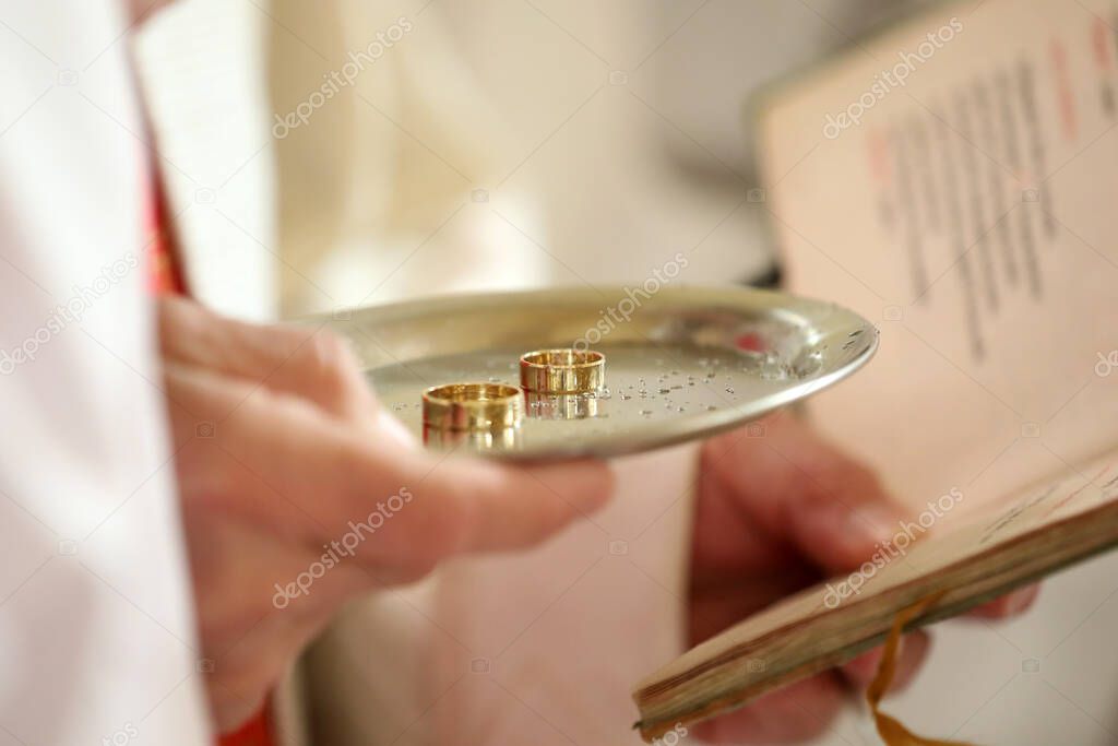 The ceremony of putting on rings during a wedding in a church