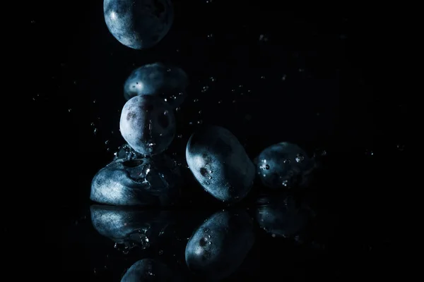 Olgun yaban mersini ve siyahta izole su damlaları