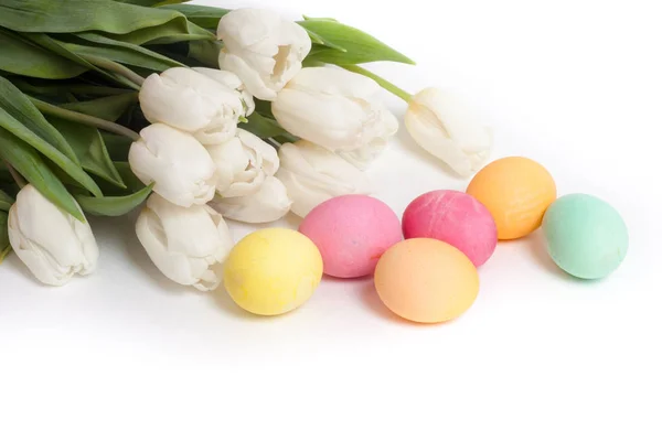Beyaz Laleler ve üzerinde beyaz izole boyalı Paskalya yumurtaları