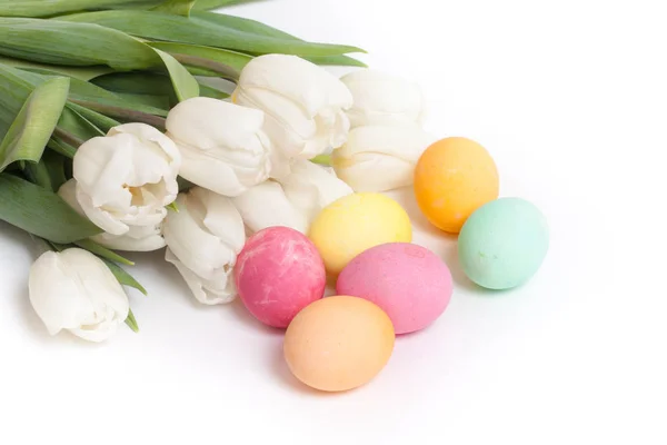 Boyalı Paskalya yumurtaları ve beyaz zemin üzerine lale