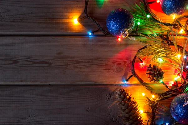 Garland en kerstboom takken op houten tabblad — Stockfoto