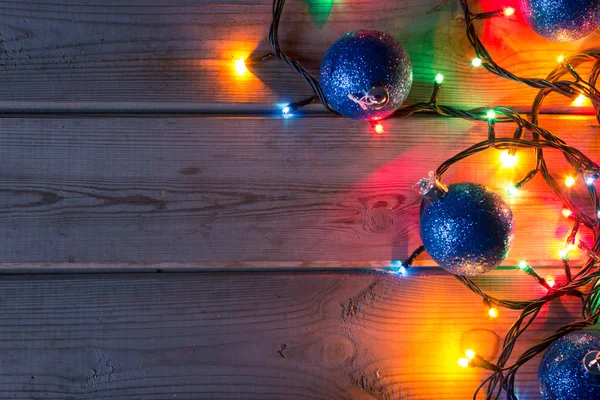 Guirnalda de árbol de Navidad y bolas en la mesa de madera se burlan de — Foto de Stock