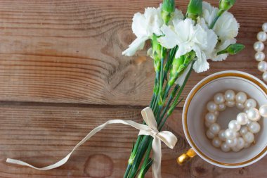 Kupası kolye ve beyaz çiçekler