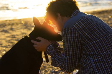 Adam ve köpeği kumsalda