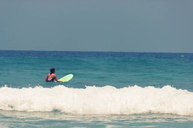 Bikini kız eğlenceli sörf tahtası üzerinde vardır.
