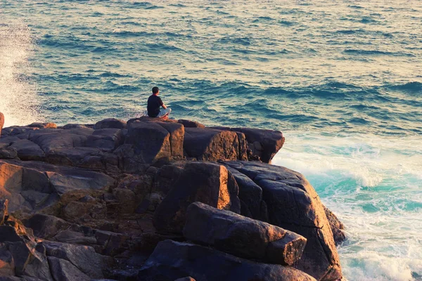 Homem meditando em uma rocha no mar — Fotografia de Stock