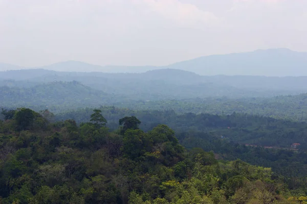 Vista sobre a colina verde e montanhas distantes — Fotografia de Stock