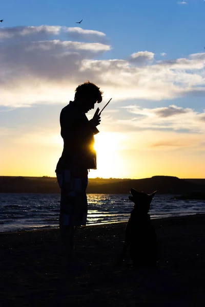 Молодий чоловік зі своїм собакою в природі — стокове фото