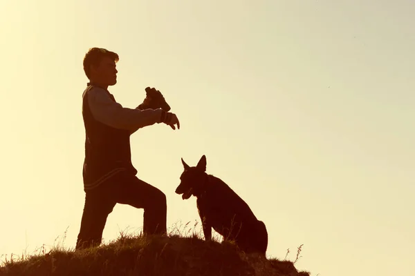 Man and his dog stand on mountain peak — Stock Photo, Image