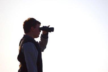 Dürbün ile gün batımını izlemek adam silüeti