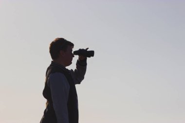 Dürbün ile gün batımını izlemek adam silüeti