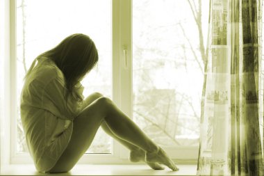 Sevimli üzgün kız evde pencere yakınındaki