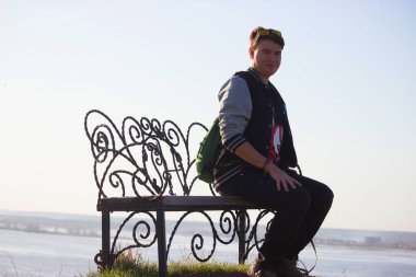 Genç adam bir tezgah üzerinde dinlenmek