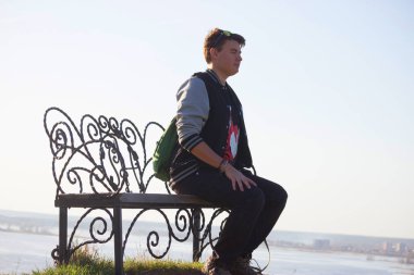 Genç adam bir tezgah üzerinde dinlenmek