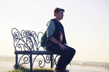 Genç adam bir tezgah üzerinde dinlenmek