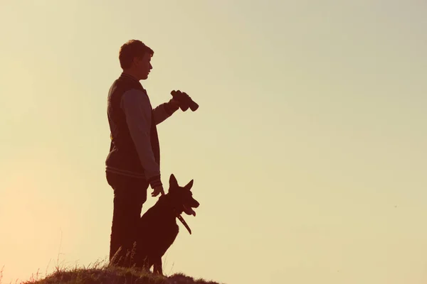 Mann und Hund stehen auf Berggipfel — Stockfoto