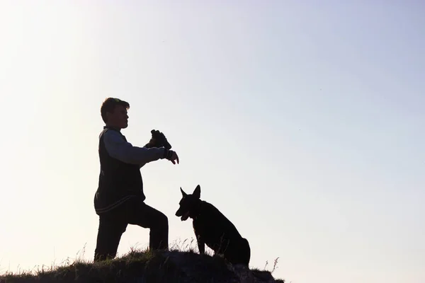 Mann und Hund stehen auf Berggipfel — Stockfoto
