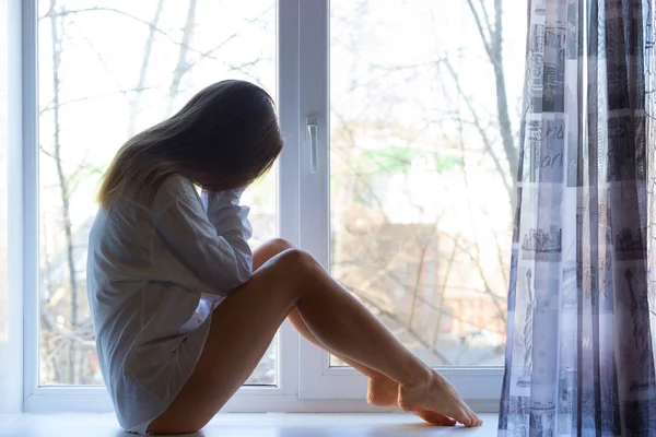 Мила сумна дівчина біля вікна вдома — стокове фото