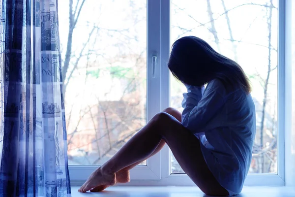 Sevimli üzgün kız evde pencere yakınındaki