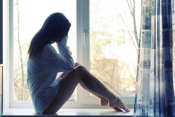 Sevimli üzgün kız evde pencere yakınındaki