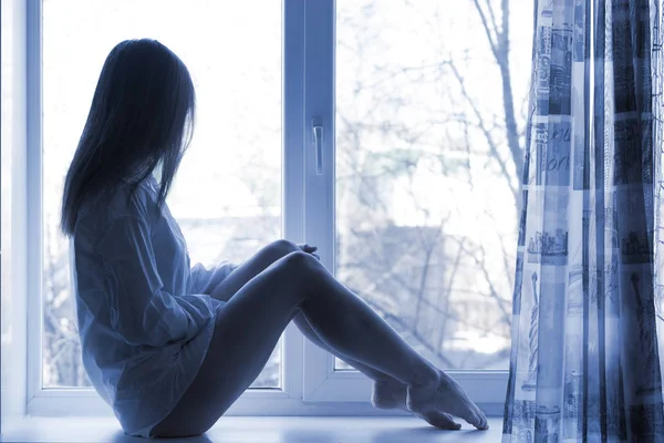 Сексуальная девушка сидит на окне — стоковое фото