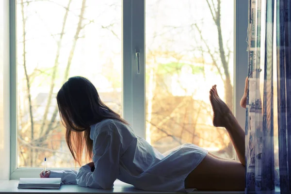 Attraktives Mädchen lag auf einem Fenster — Stockfoto