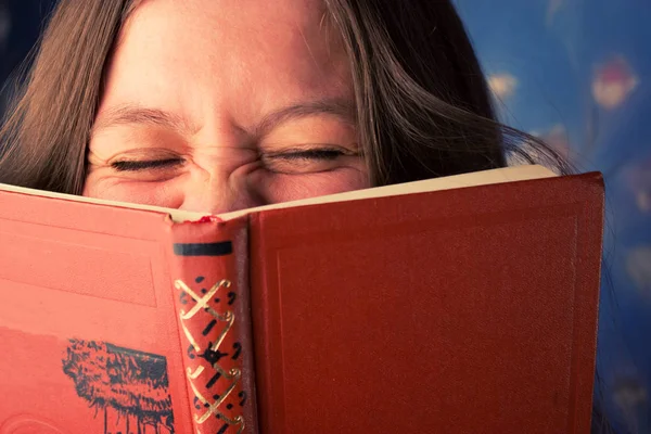 Frau liest Buch zu Hause und lacht — Stockfoto