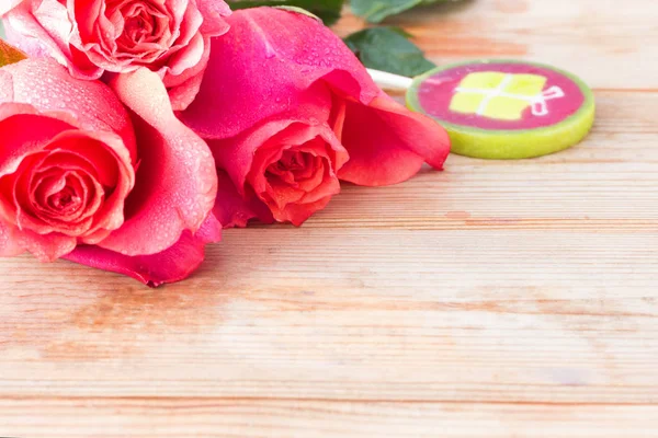 Rosarote Rosen und Süßigkeiten auf dem Tisch — Stockfoto