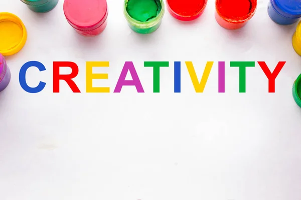Creatividad concept.colorful signo y latas de pintura — Foto de Stock