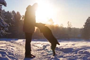 Adam köpek kış gününde yürür.