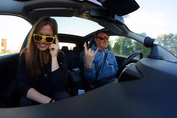 man and woman in sunglasses in the car. travel by car concept
