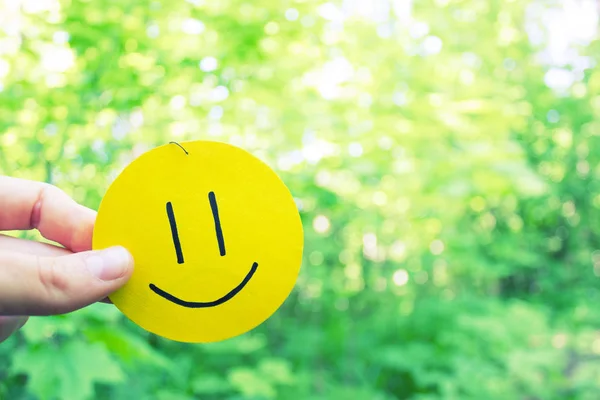 Жовта посмішка на фоні зеленого листя — стокове фото